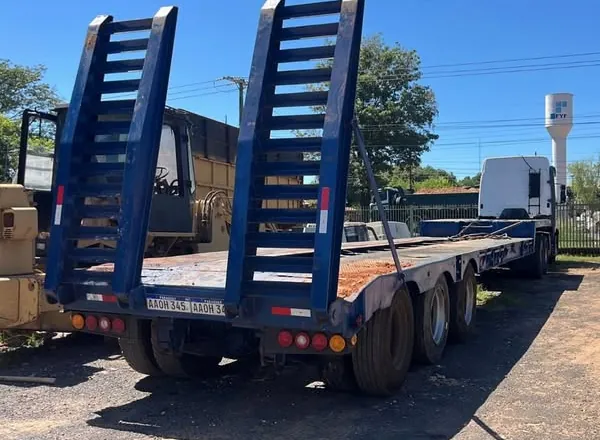 Carretón transportador de maquinaria de tres ejes con dos rampas traseras azules